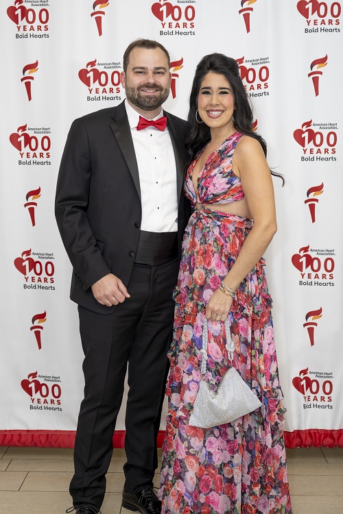 Smiling couple in front of American Heart Association 100 Years of Bold Hearts backdrop